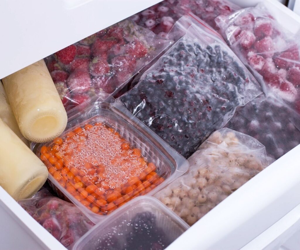 freezer drawer full of bags and containers for frozen fruit and vegetables